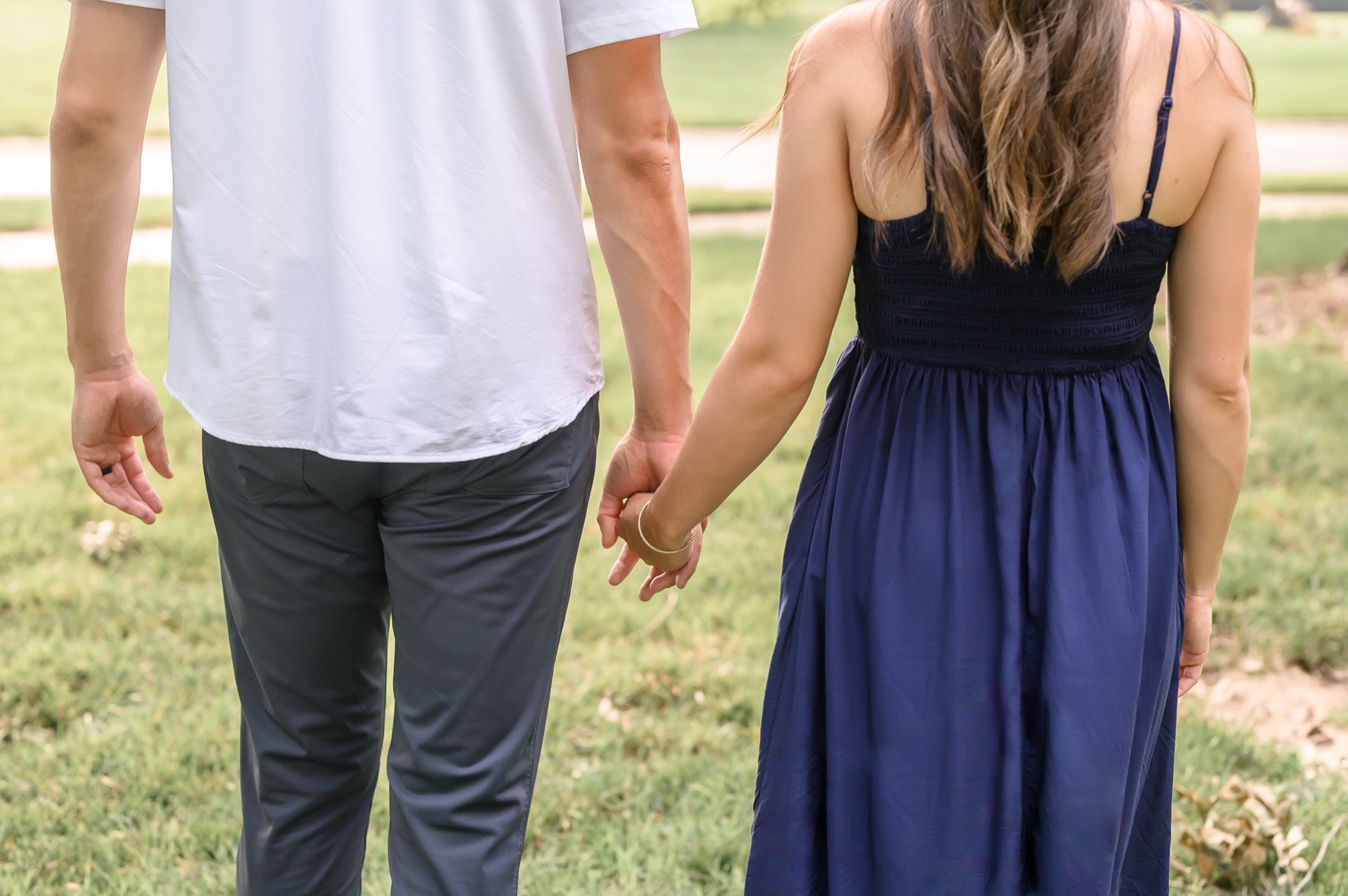 Couple walking hand in hand through a peaceful park