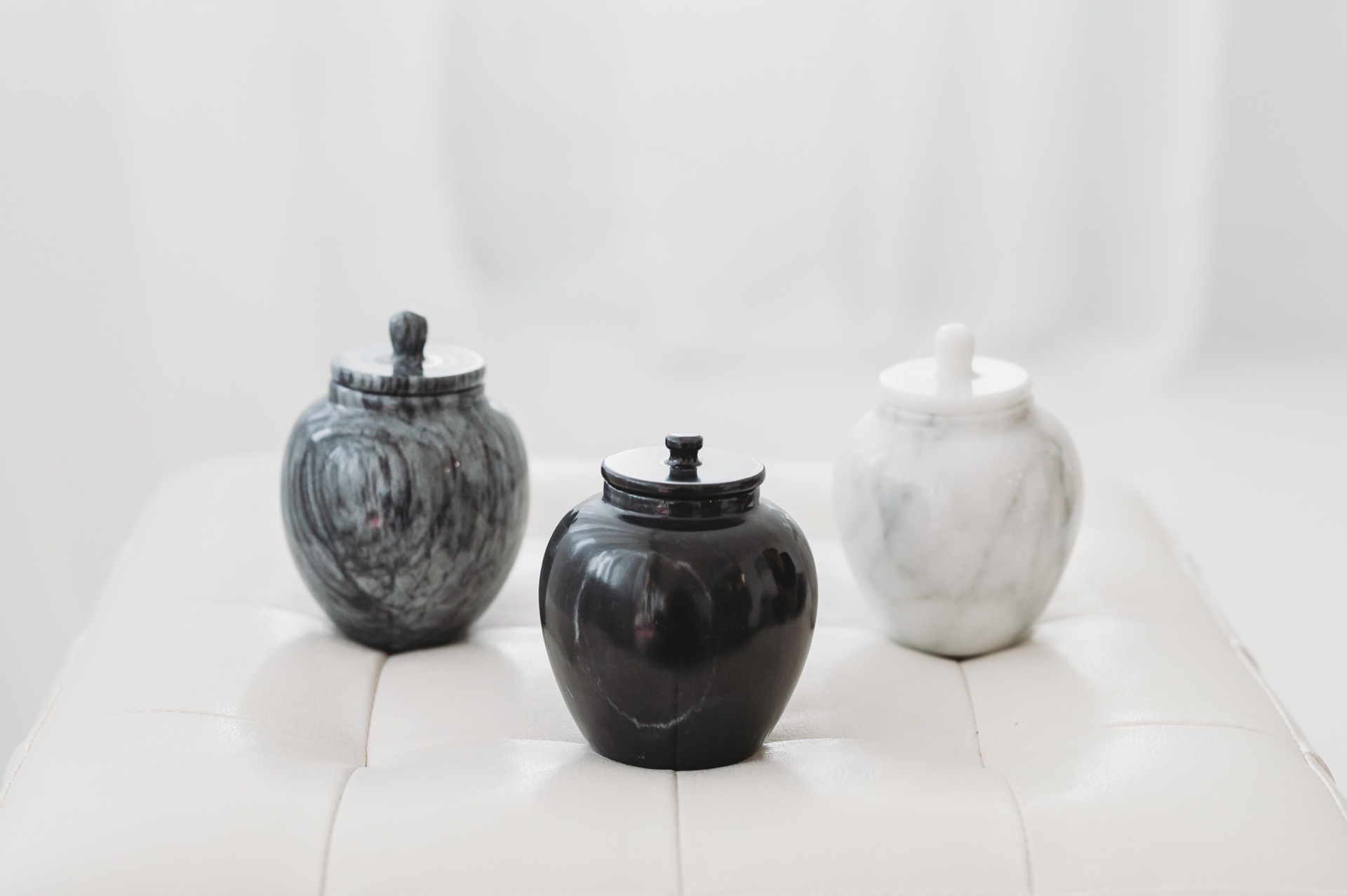Three marble urns in black, white, and grey
