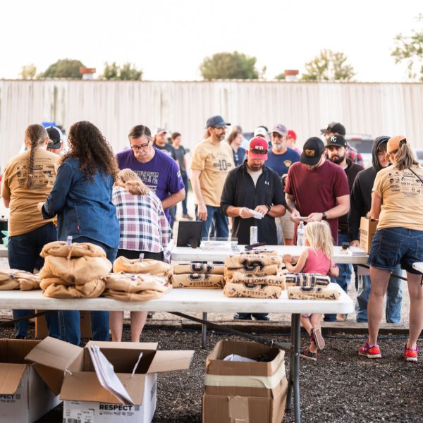 Crowd_of_people_gathered_around_tables_filled_with_sweatshirt_boxes