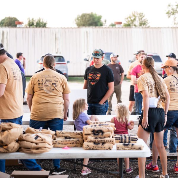 Group_of_people_at_an_event_gathered_around_tables_with_supplies