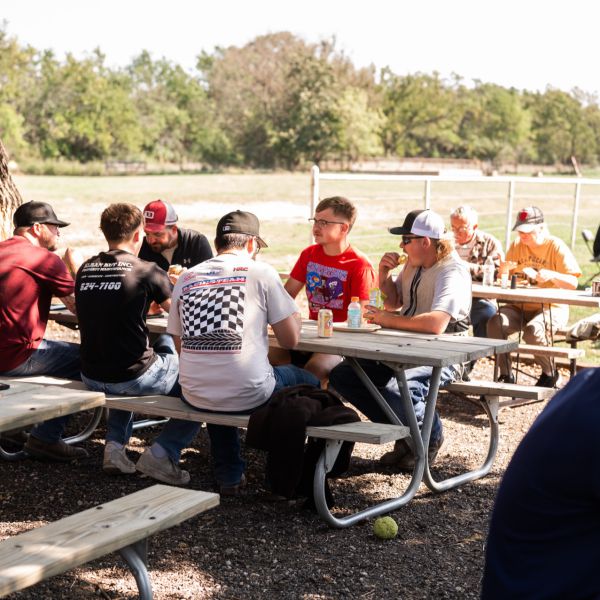 Group_of_people_eating_outside_under_trees_during_daytime