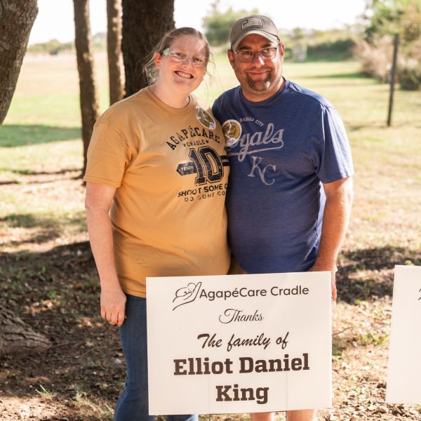 Man_and_woman_behind_sign_outdoors