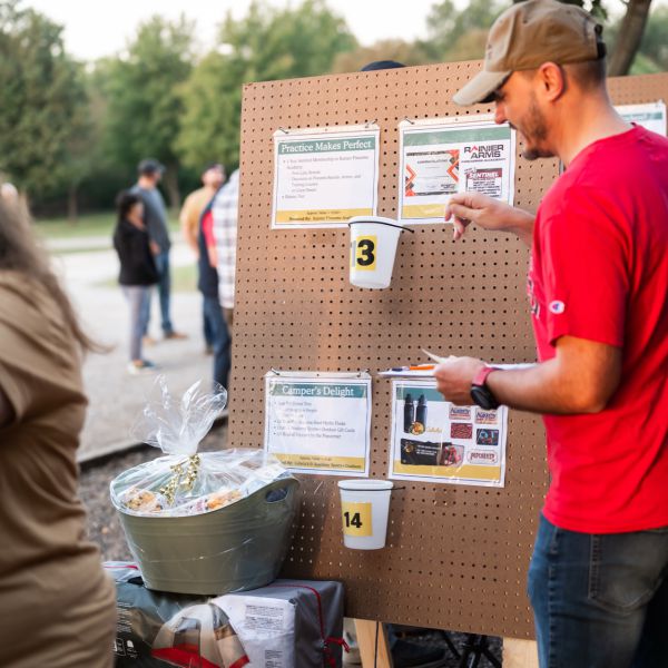 Man_placing_raffle_tickets_in_outdoor_setting