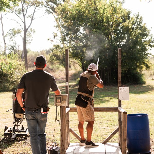 Man_shooting_clay_outside_with_assistant