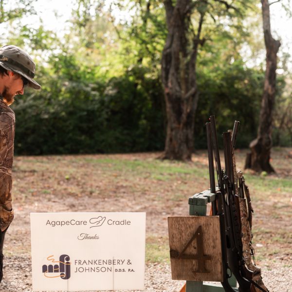 Man_standing_near_clay_shoot_and_sign