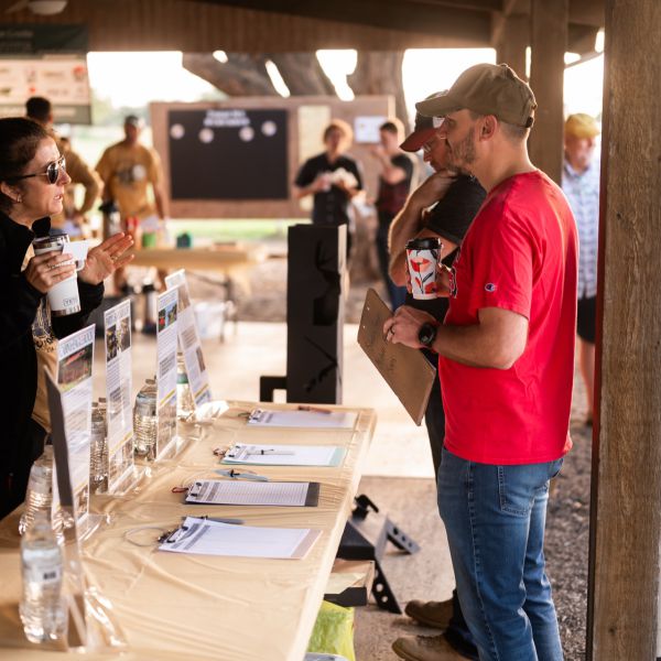 Man_talking_to_woman_behind_table_with_pamphlets