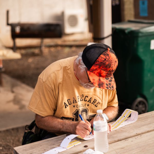 Man_writing_at_picnic_table