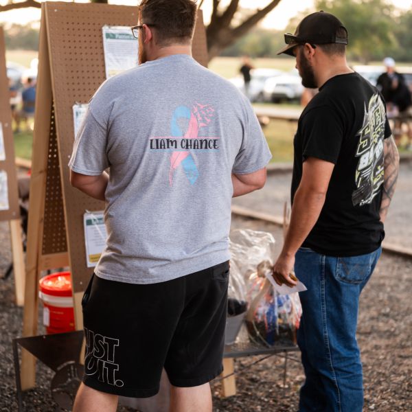 Men_at_outdoor_event_studying_information_board