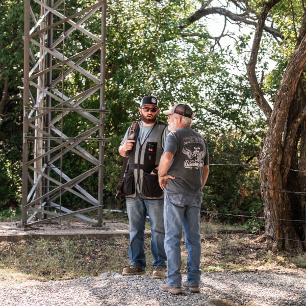 Two_men_talking_under_a_radio_tower