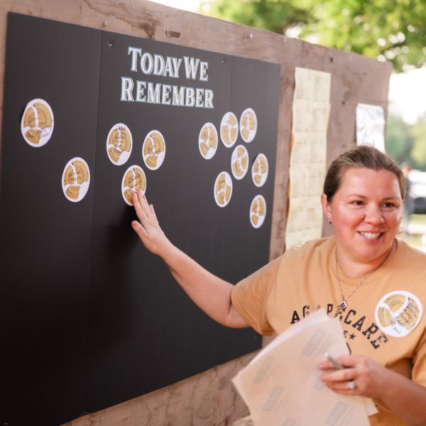 Woman_pinning_names_to_blackboard_with_white_markers