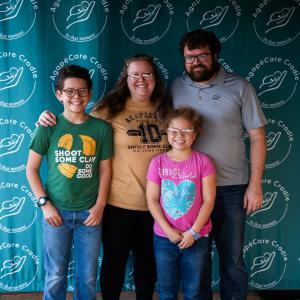 Family_photo_with_smiles_posing_in_front_of_backdrop