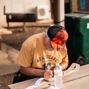 Man_writing_at_picnic_table