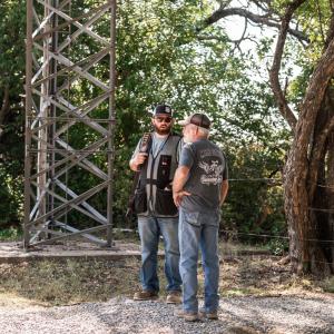 Two_men_talking_under_a_radio_tower